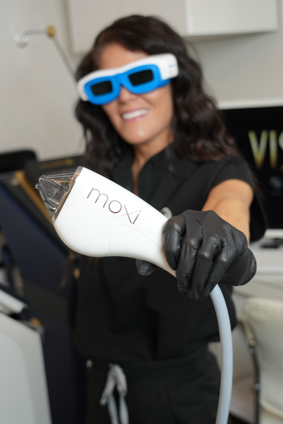 Olympia Morris holding the Sciton MOXI laser handpiece in the clinic